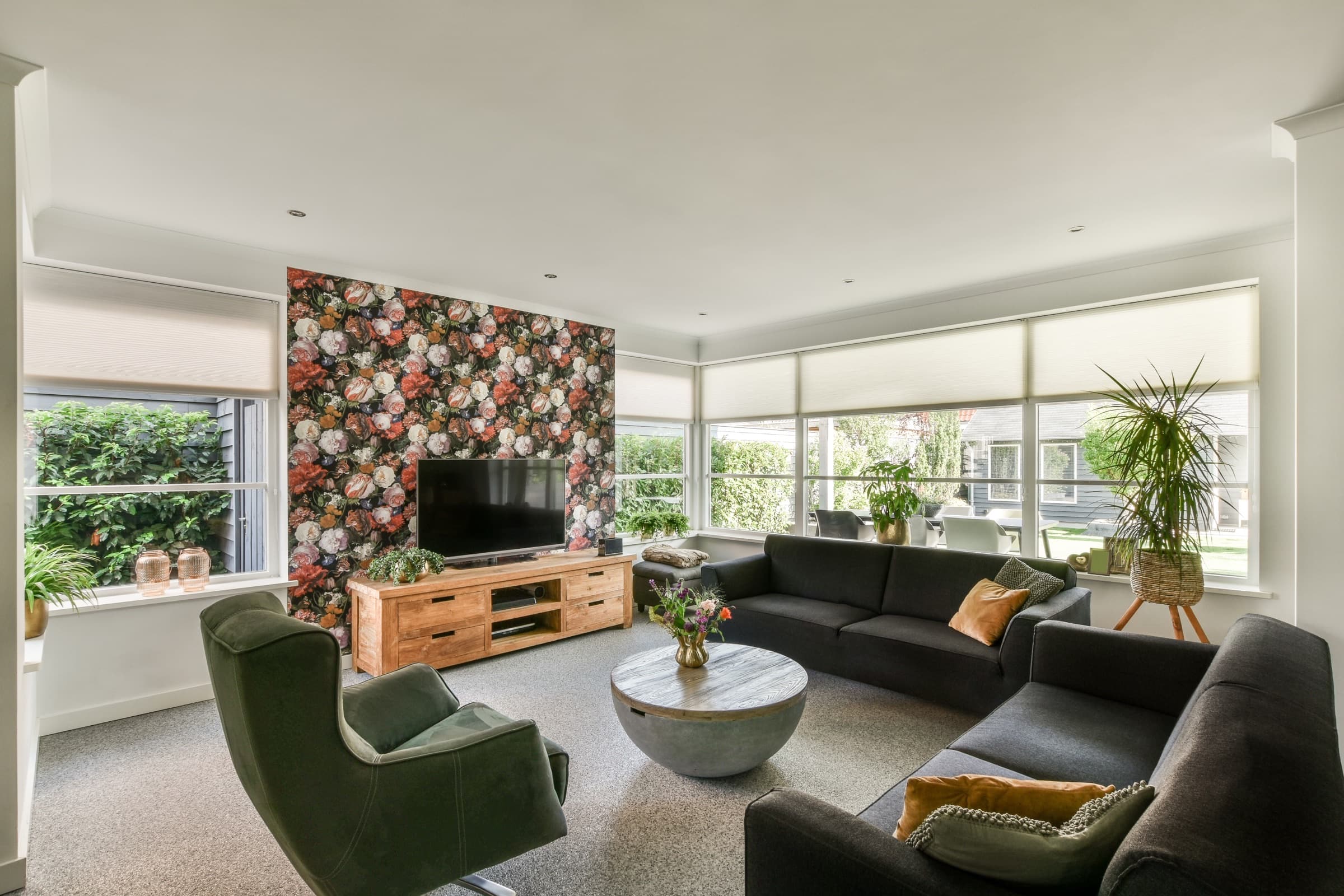 Renter-friendly floral peel-and-stick wallpaper on a living room accent wall behind a wall-mounted TV